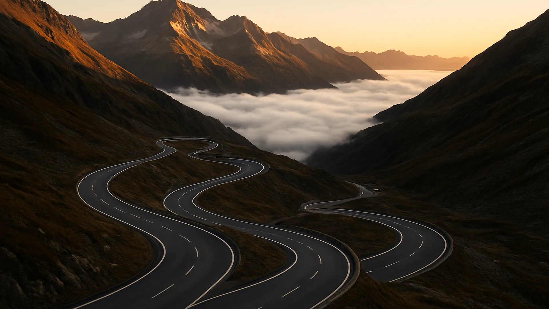 Route de col en lacets au-dessus des nuages au lever du soleil